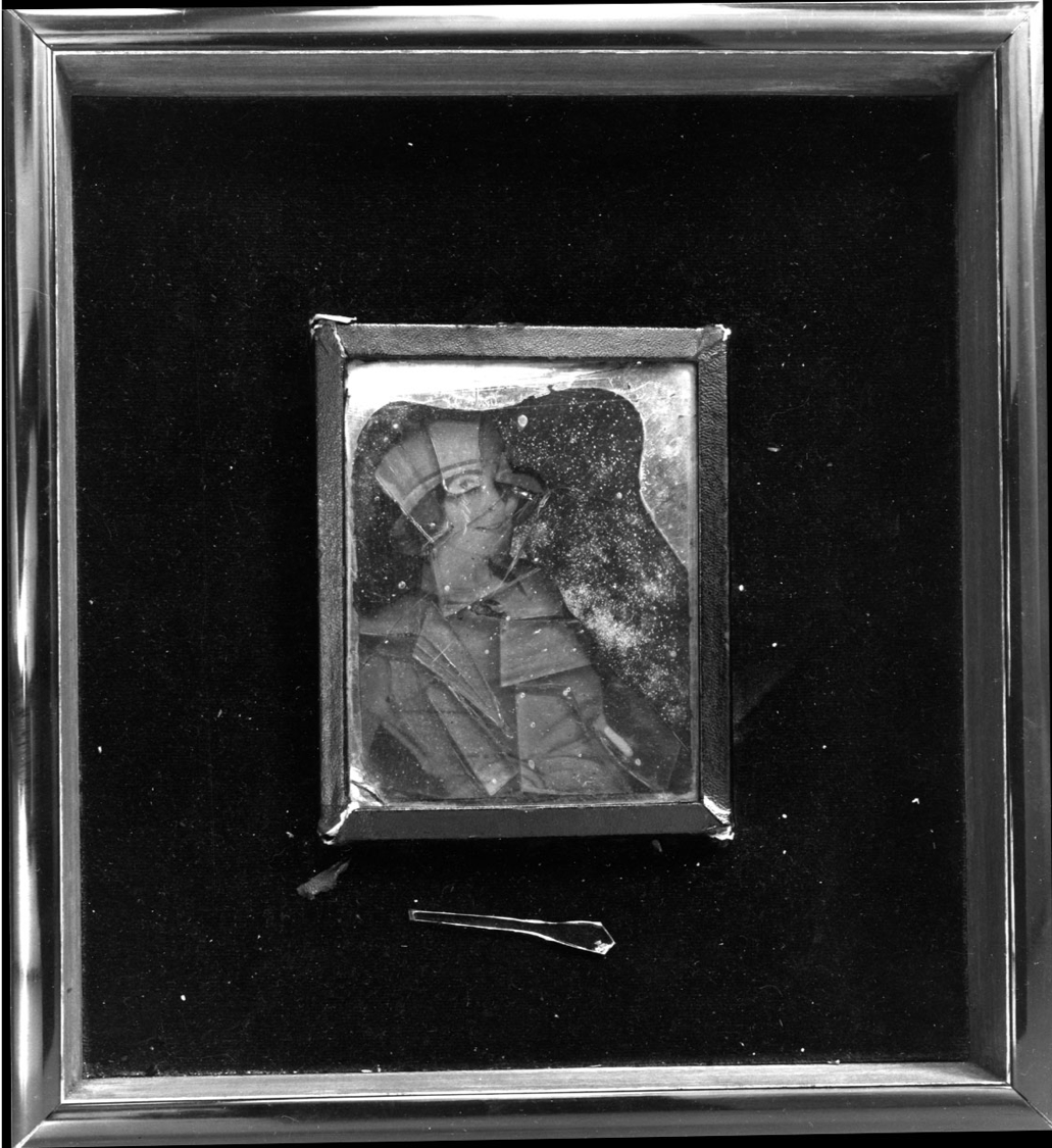 small box containing photo of Mina Loy under glass, framed within larger box.