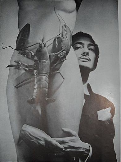 Dali posed behind a female nude woman's torso wearing a lobster