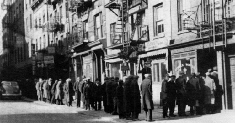 Men line up on street to enter Catholic Worker storefront, presumably to seek aid.