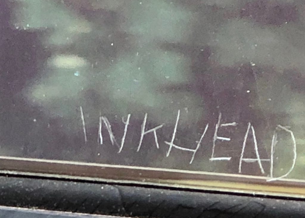 photo of INKHEAD scratched on glass