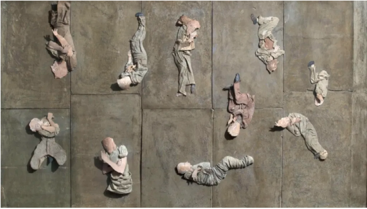 Collage of cardboard, paper and rags depicting human figures lying on sidewalks
