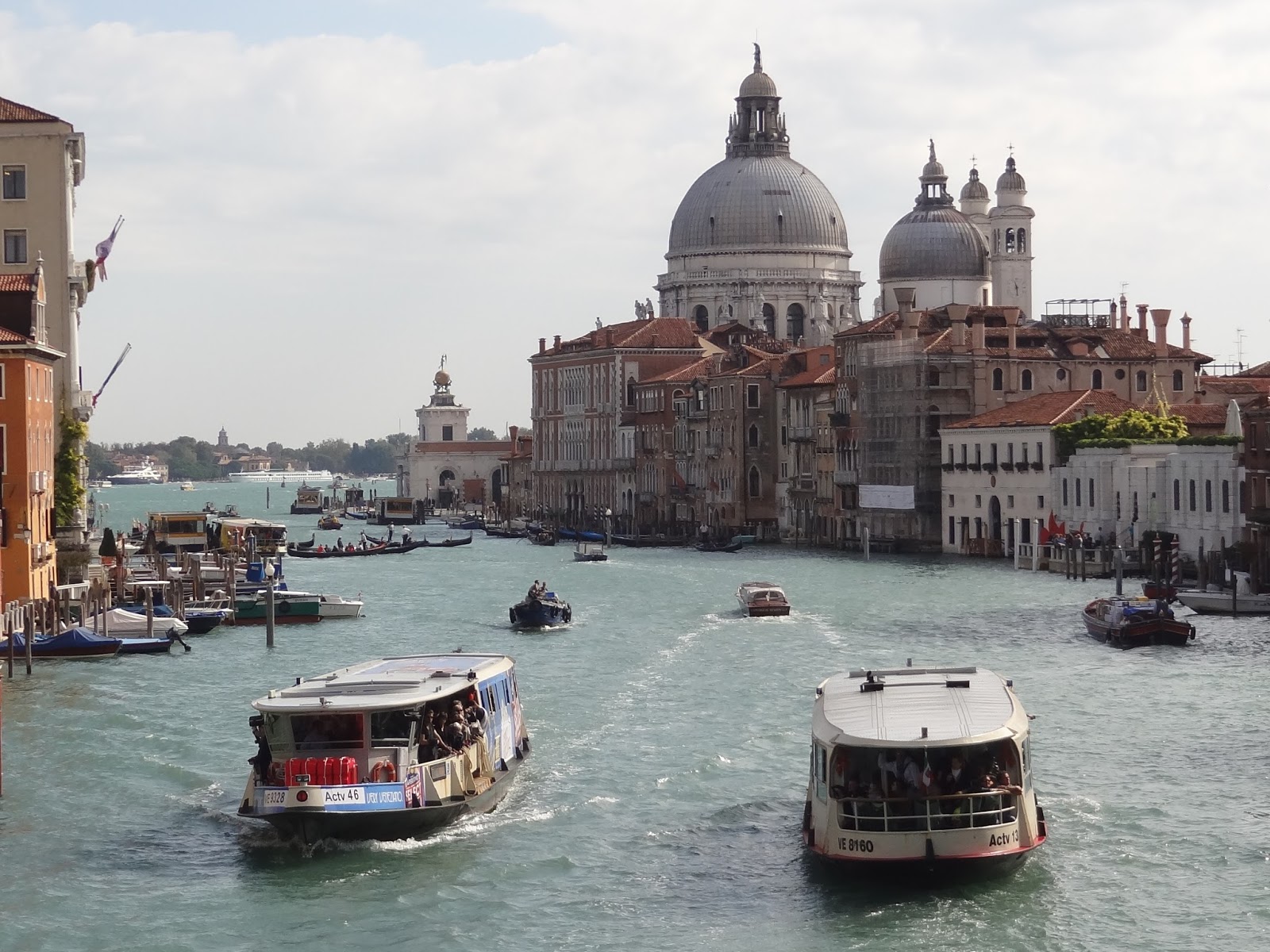 Grand canal containing water taxes with St. Mark's Basilica looming